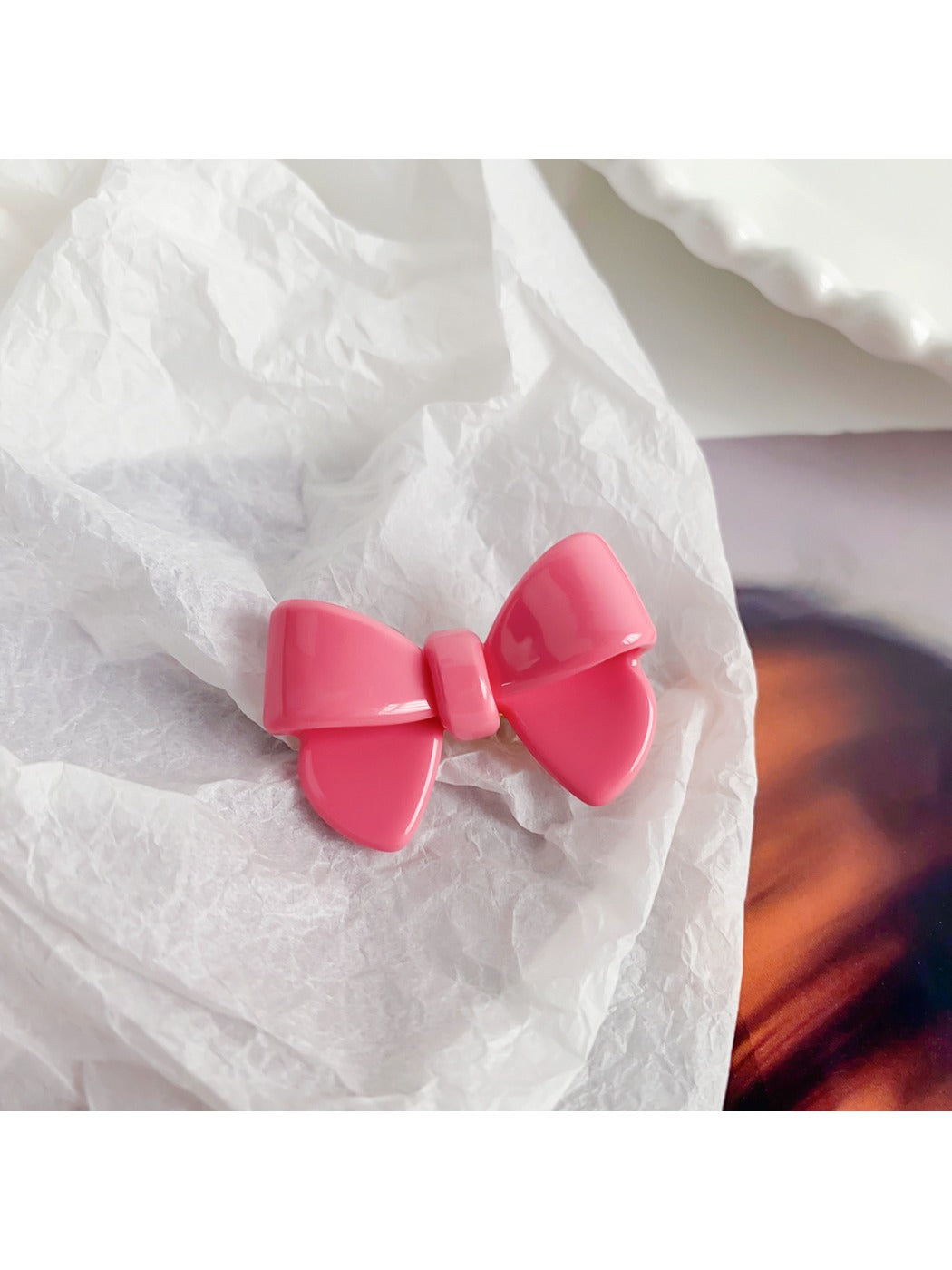 Beau delicate bow hair clip held in hand showing size and texture