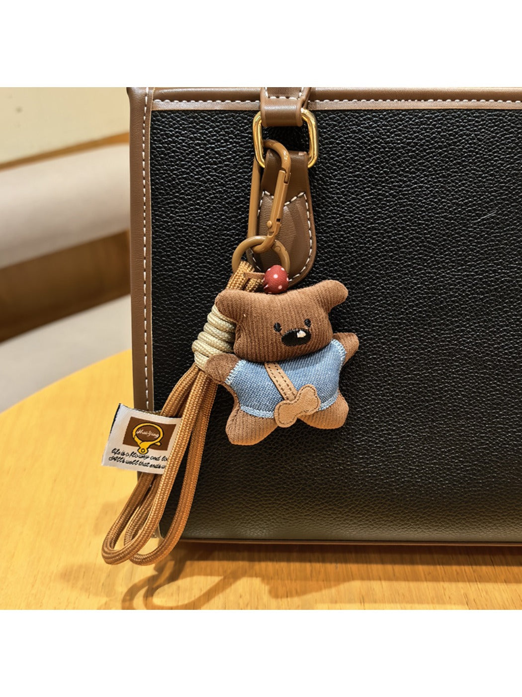 Fabric bear keychain displayed with other small accessories on a table