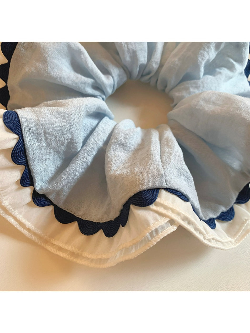 Side view of Gifty scrunchie highlighting gathered fabric and smooth texture
