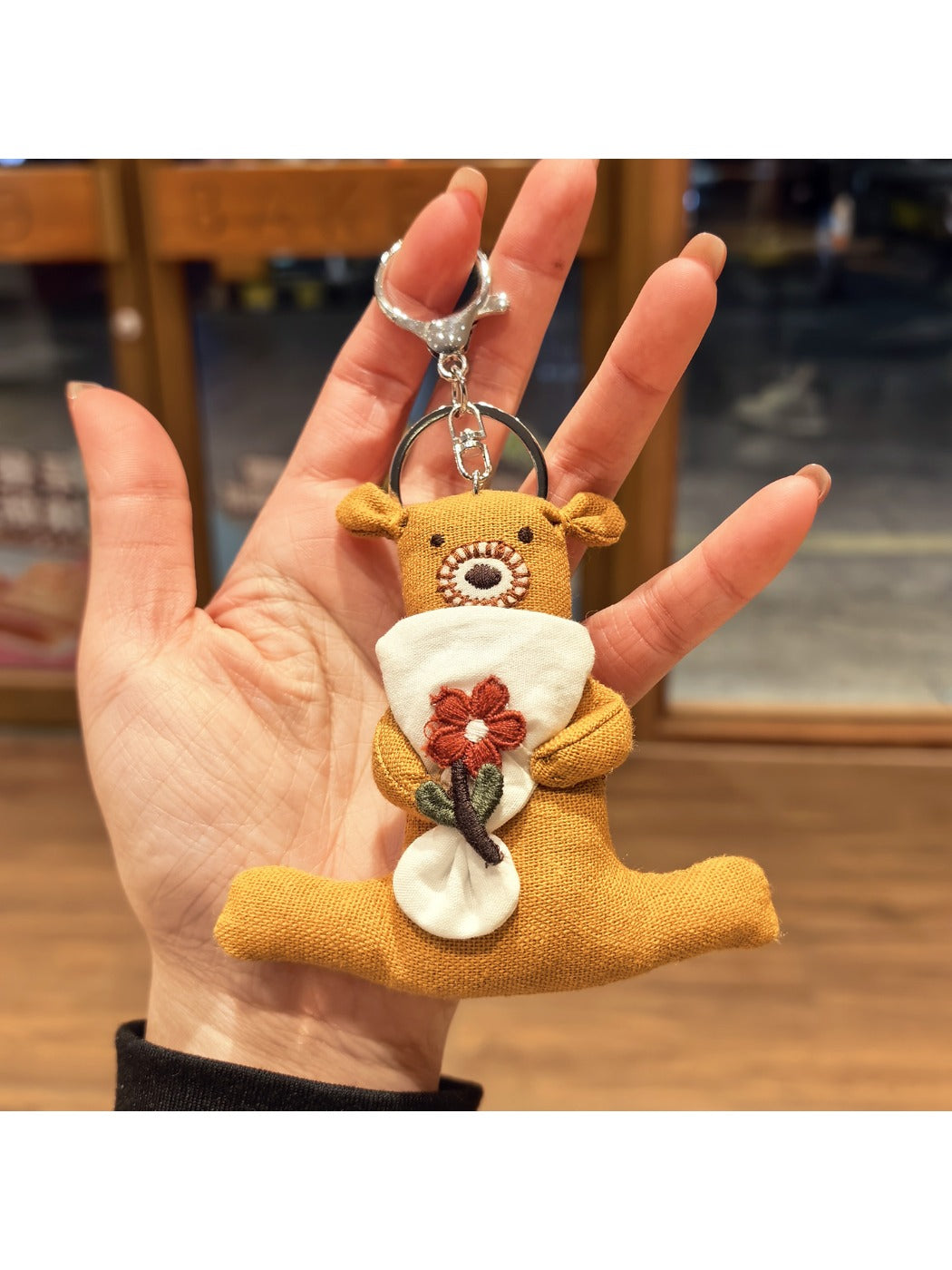 Bear keychain attached to a backpack zipper pull in an outdoor setting