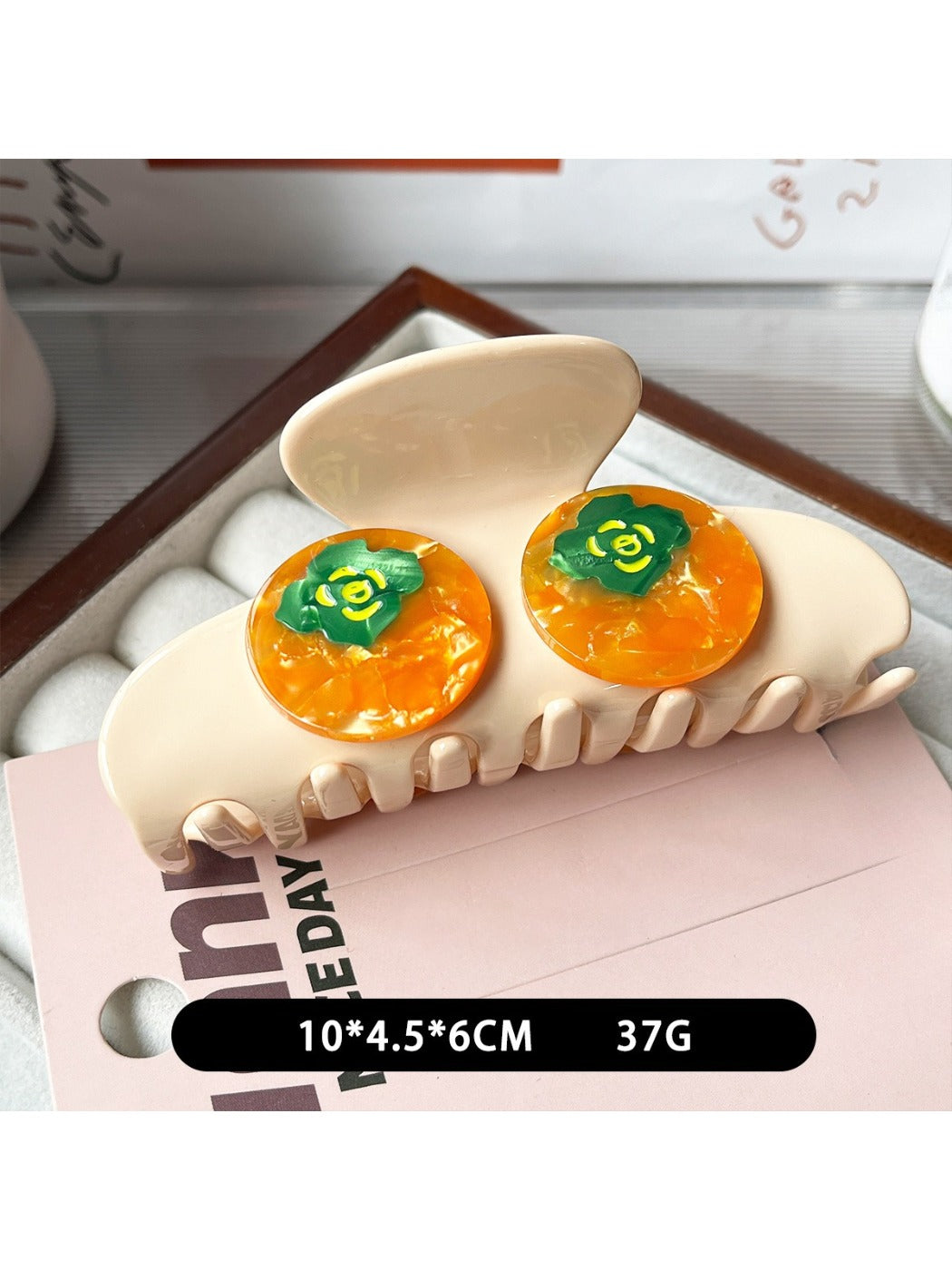 Yellow fruit shaped claw clip securing hair in a bun