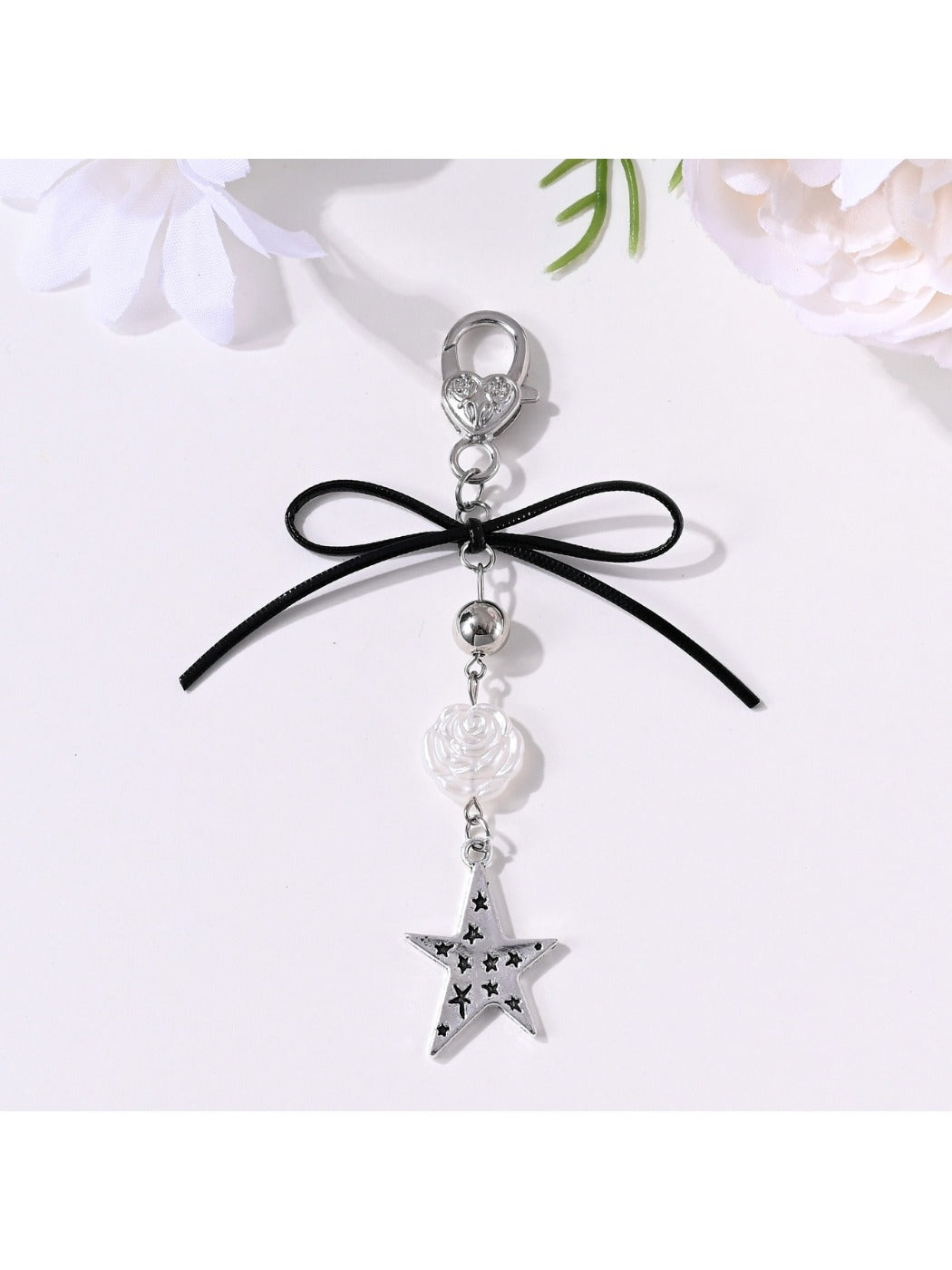 Keypus keychain with bow, star, and heart charms on a white background