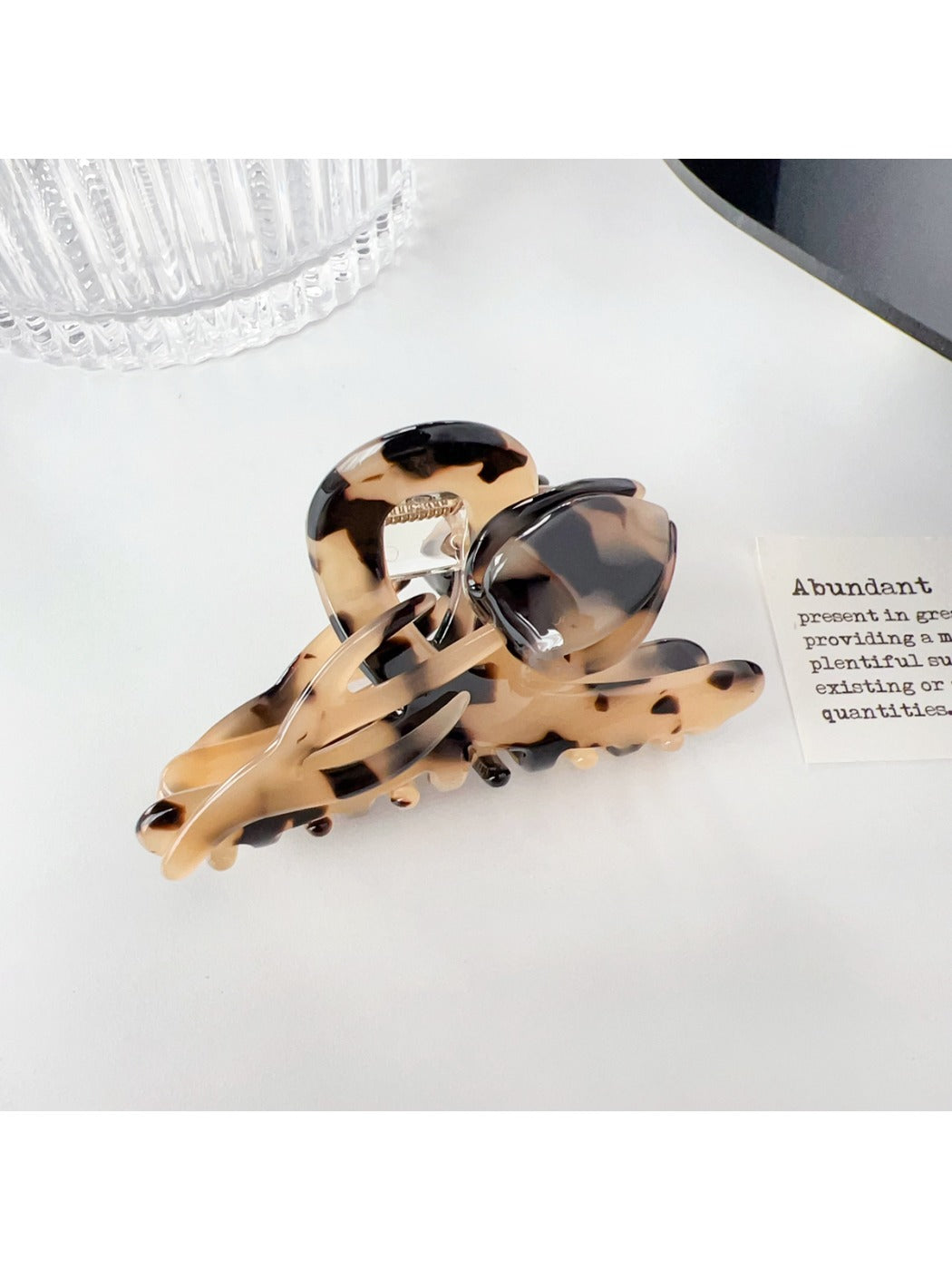 Beau colorful floral hair claw clip featured in lifestyle setting with plants