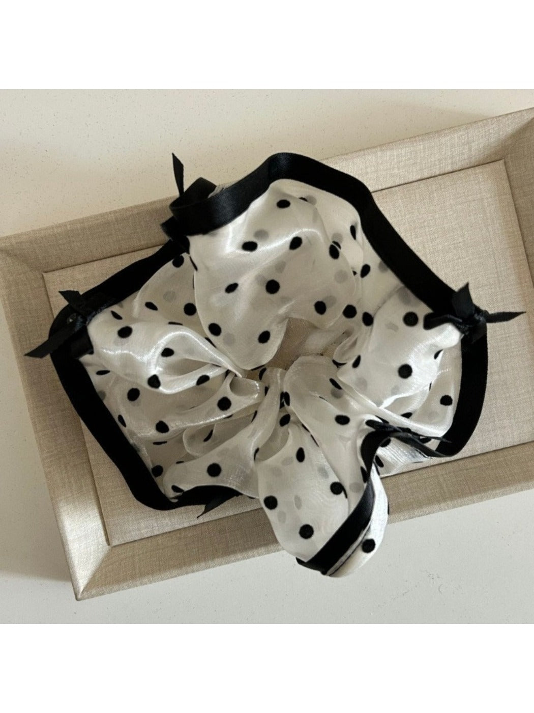 Flat lay of Gifty bow tulle scrunchie alongside matching hair accessories on neutral background