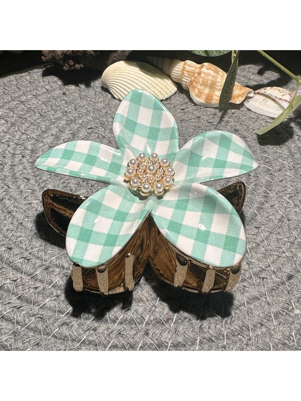 Beau checkered flower hair clip displayed on a wooden surface with natural lighting