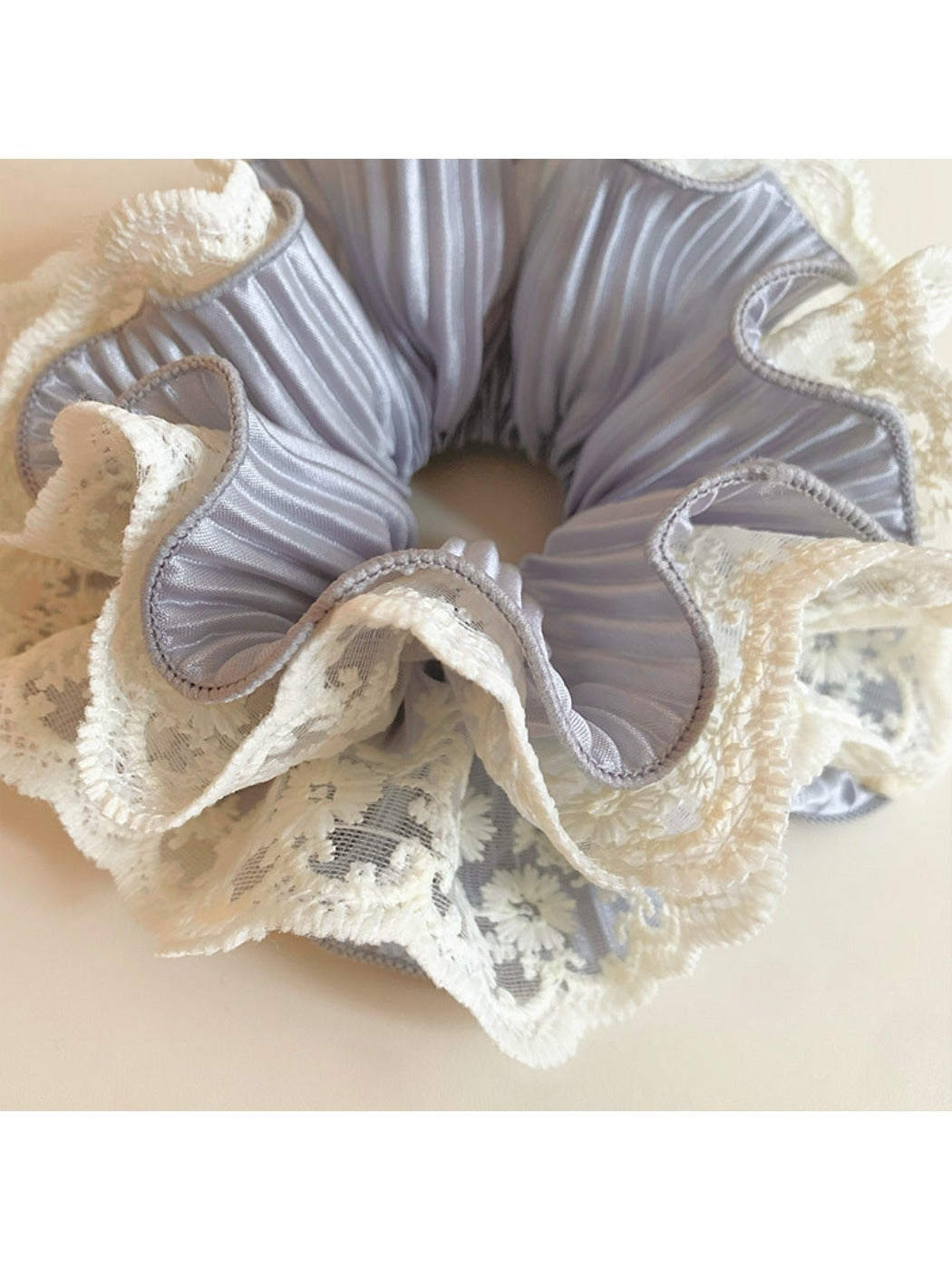 Side view of Gifty sweet ruffled scrunchie highlighting the elastic band and fabric layers