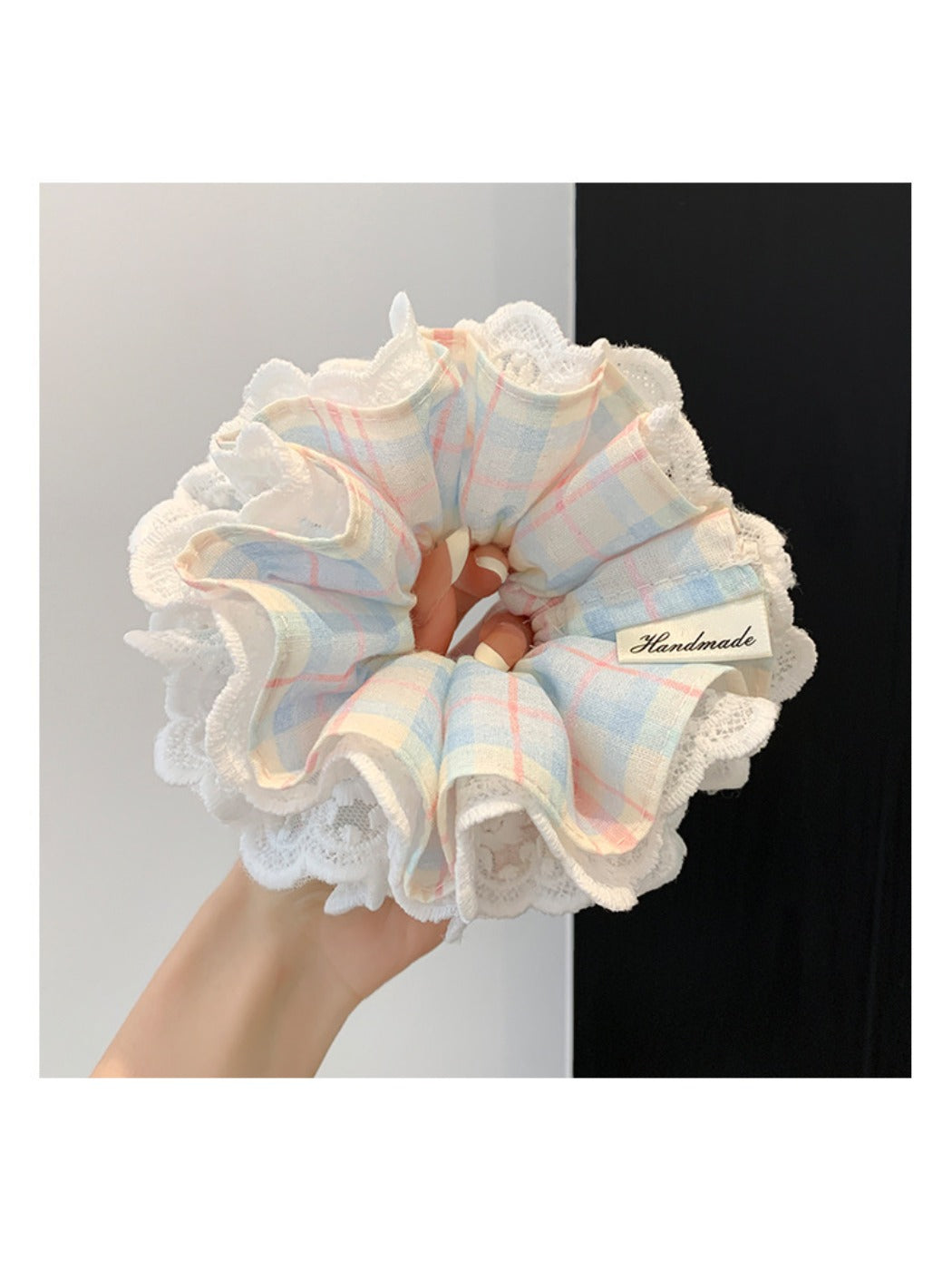 Blue plaid lace trim scrunchie styled on a wrist with soft lighting