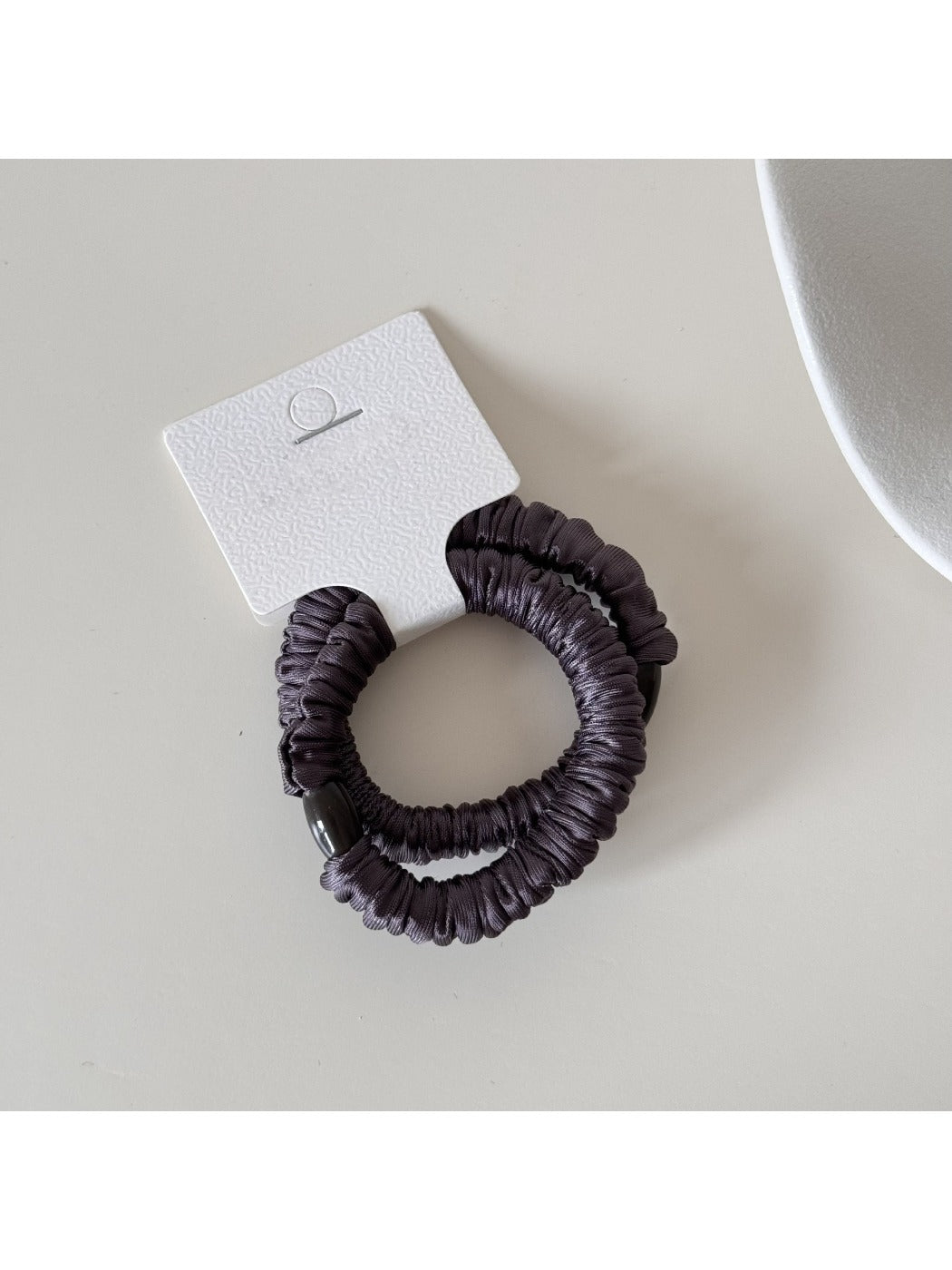 Model with long hair wearing Gifty satin hair tie styled in a low bun
