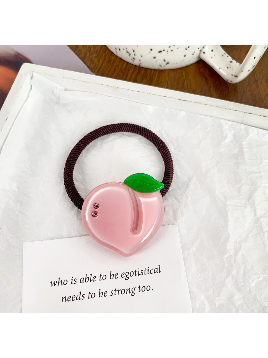 Set of colorful fruit-themed hair ties packaged in a clear plastic box