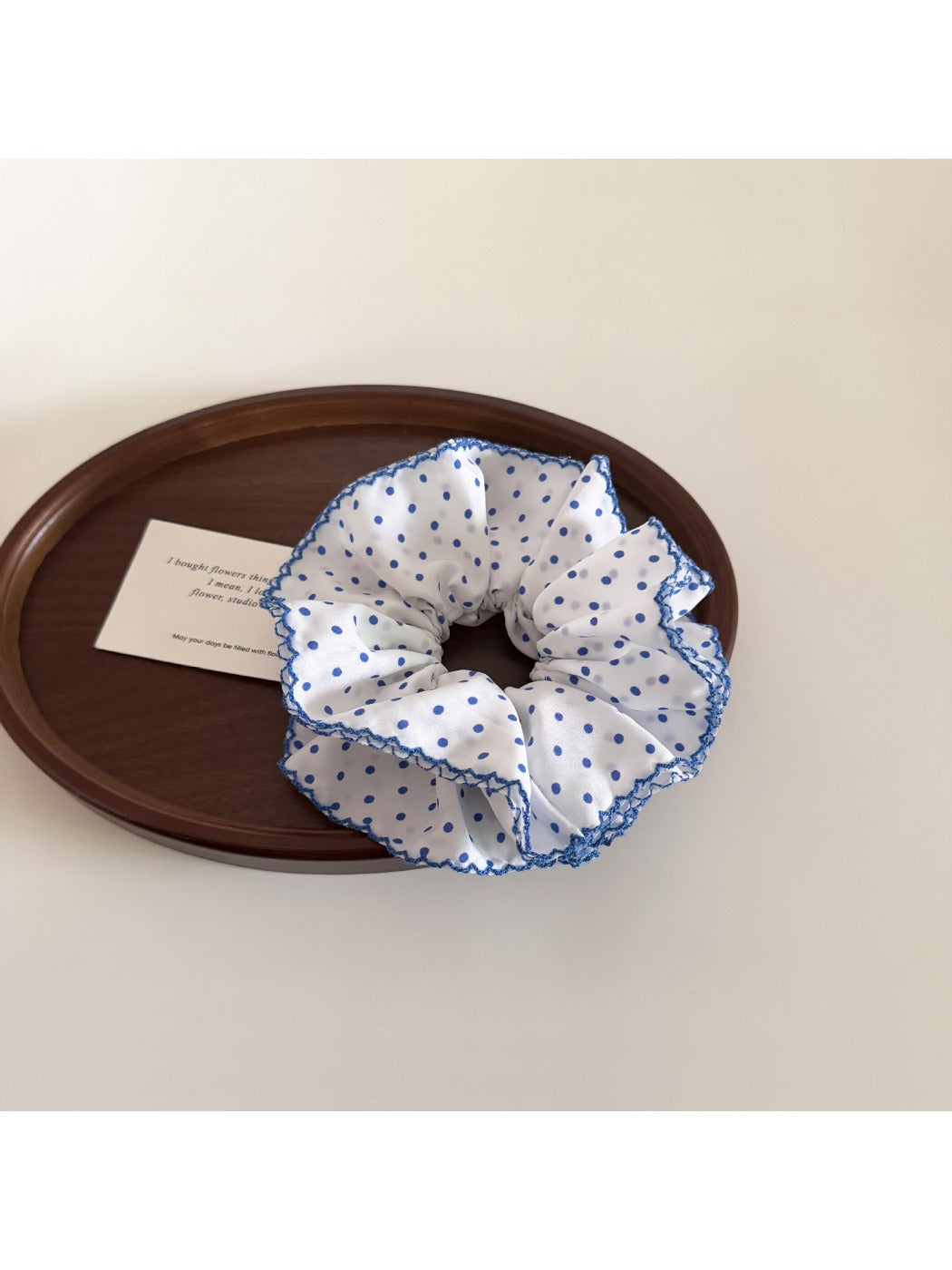 Model wearing delicate blue polka dot scrunchie in hair