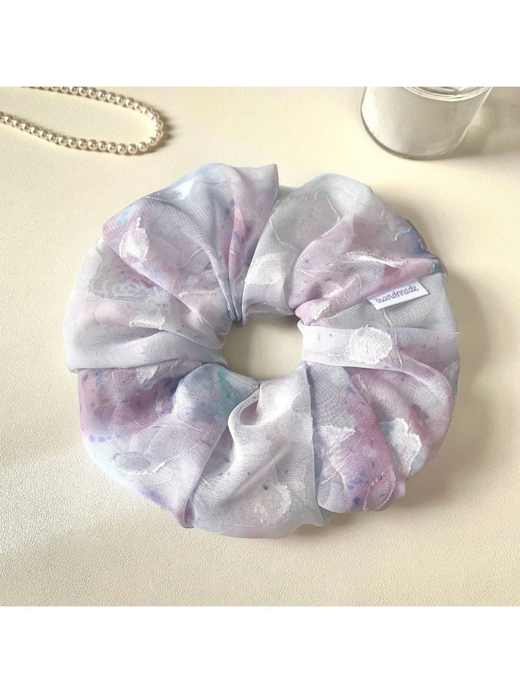 Gifty scrunchie styled with matching accessories on a wooden surface