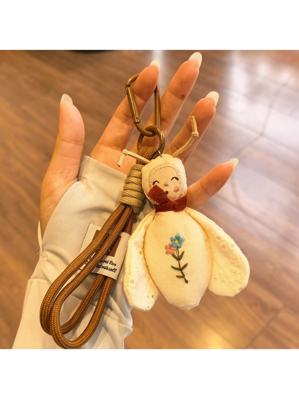 Bee charm keychain hanging from a backpack zipper pull