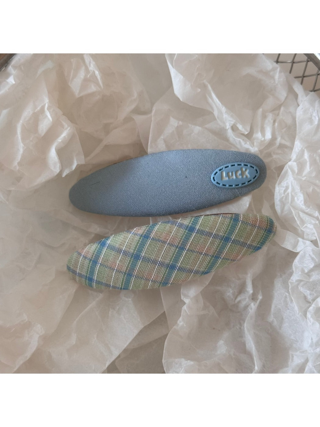 Beau colorful oval hair clip displayed with packaging on a neutral background
