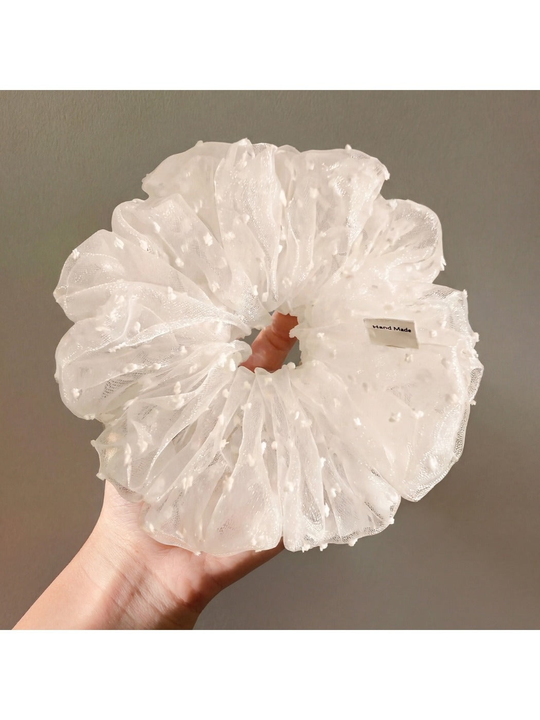 White tulle scrunchie with polka dots styled in a woman's hair