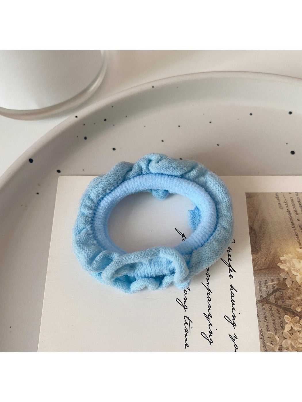 Ruffled hair ties in bright colors displayed in a small glass bowl