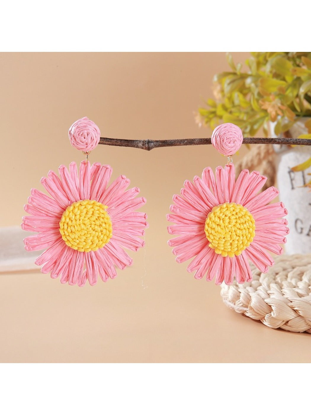 Close-up of earring hook attached to raffia woven sunflower design