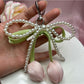 Keychain held in hand showing size and design of bow and tulip pendant