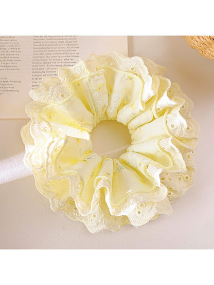 Gifty yellow ruffle scrunchie displayed flat showing gathered fabric details