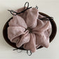 Pink ribbon bow tulle scrunchie styled with casual outfit on a model