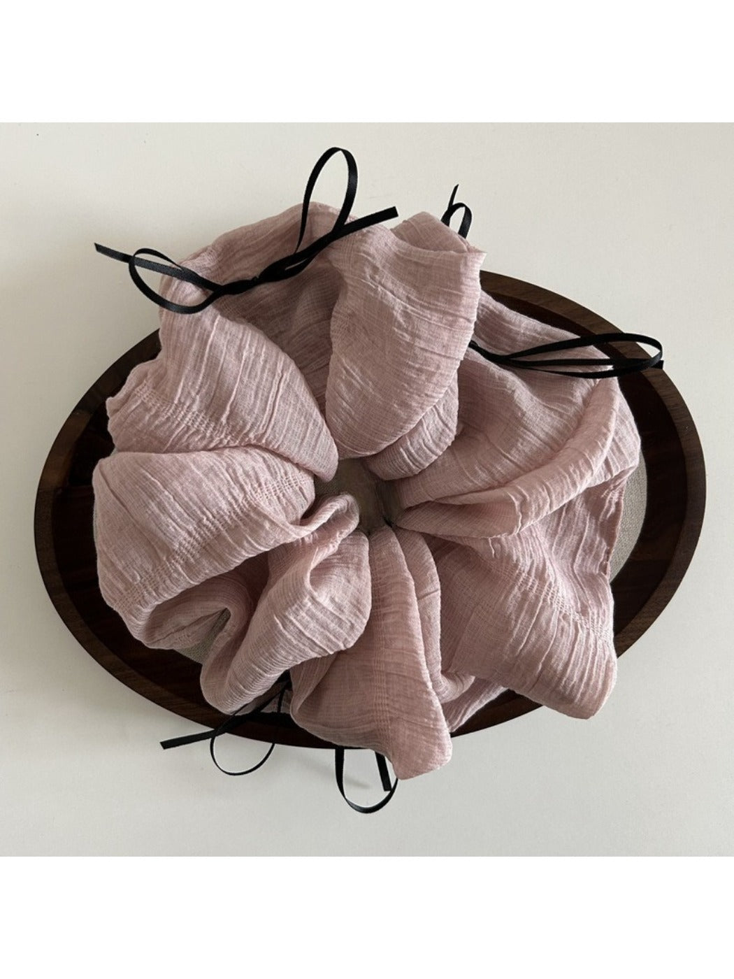 Pink ribbon bow tulle scrunchie styled with casual outfit on a model