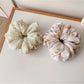 Gifty ruched scrunchie styled on a wrist with vibrant print design