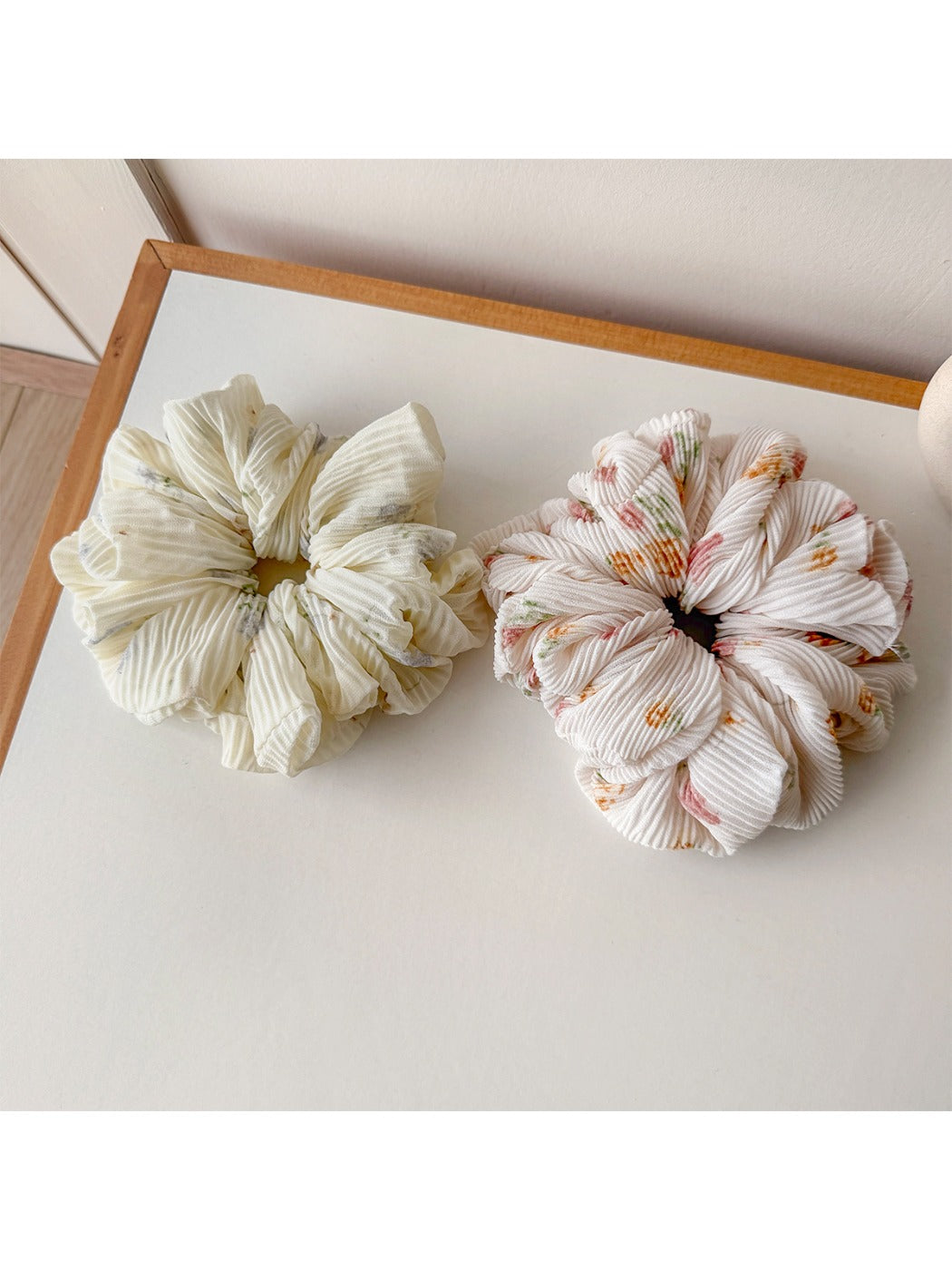 Gifty ruched scrunchie styled on a wrist with vibrant print design