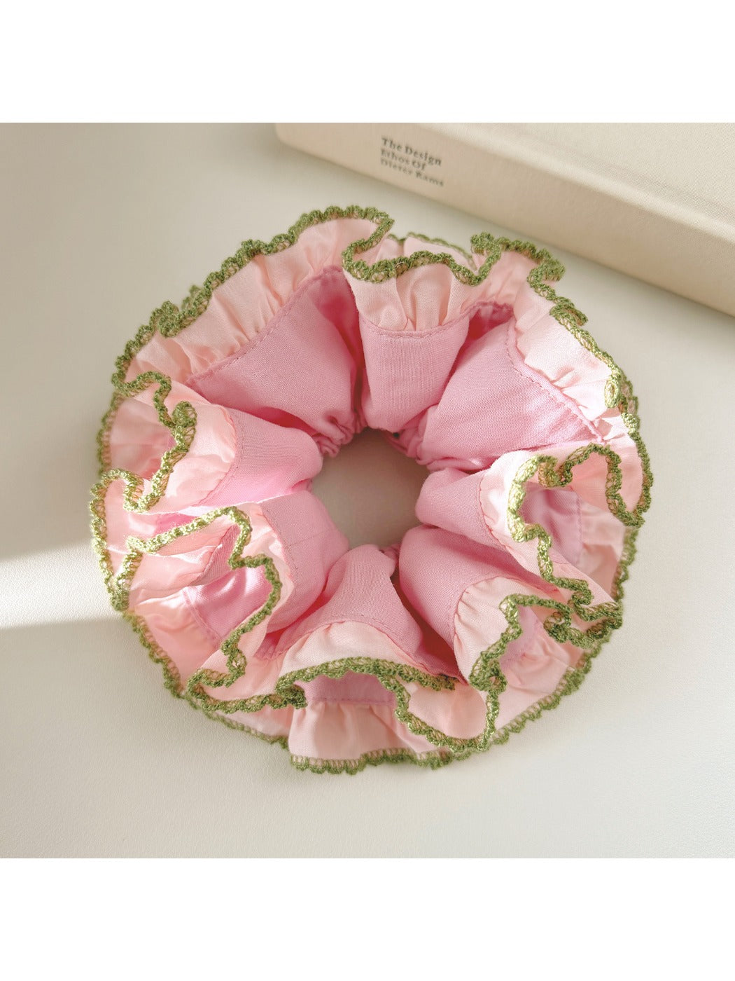 Pink lace scrunchie displayed flat showing intricate lace details and elastic band