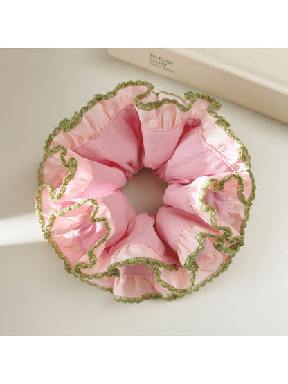 Pink lace scrunchie displayed flat showing intricate lace details and elastic band