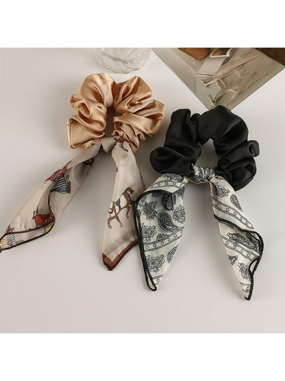 Vintage satin bow hair scrunchie styled on a model's ponytail with natural lighting