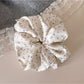 Gifty scrunchie styled with casual outfit on a fabric backdrop