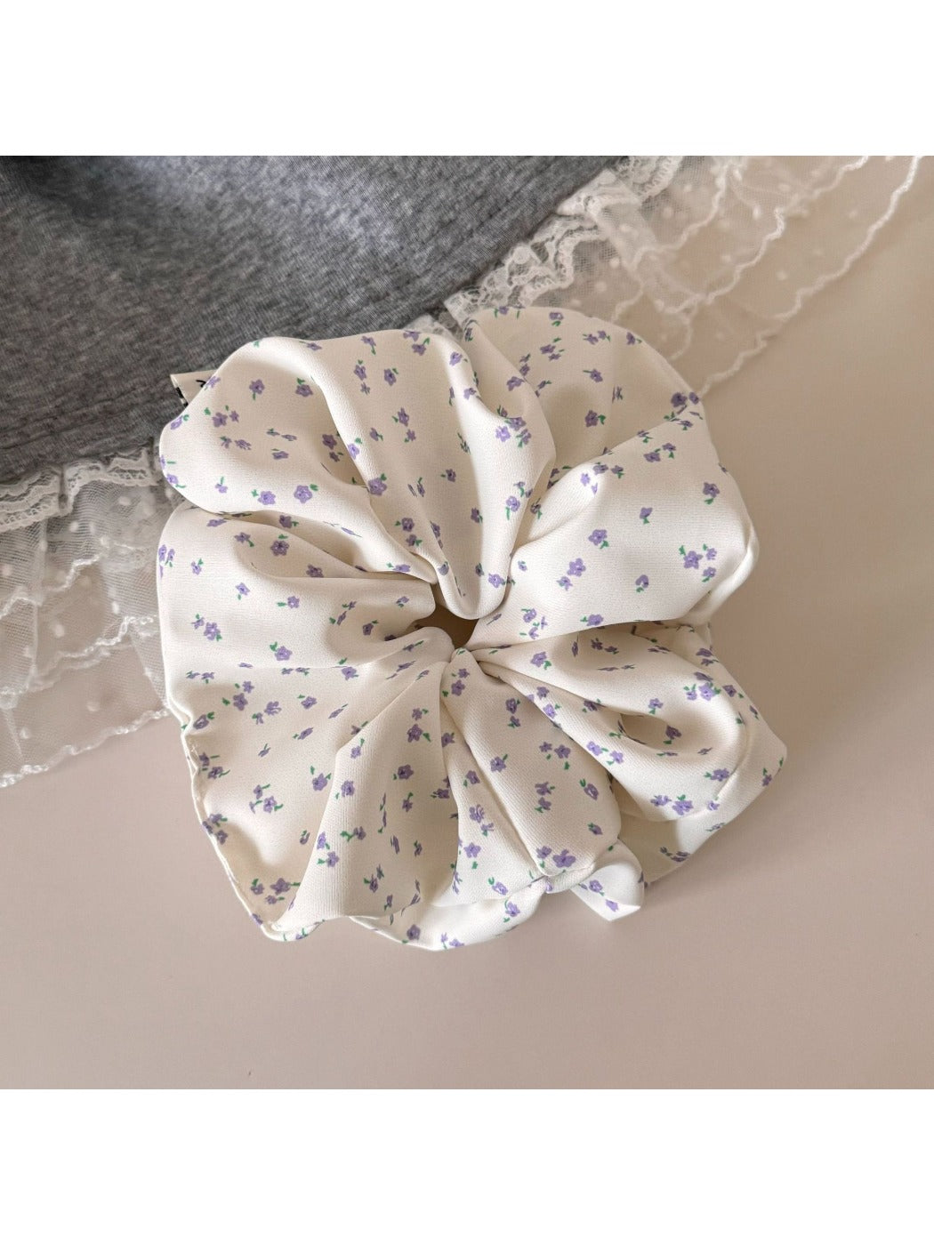 Gifty scrunchie styled with casual outfit on a fabric backdrop