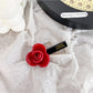 Beau floral hair clip attached to a braid in dark brown hair