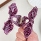 Beau leopard print claw clip held in hand displaying size and shape