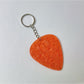 Silver textured teardrop charm keychain displayed with other metallic accessories