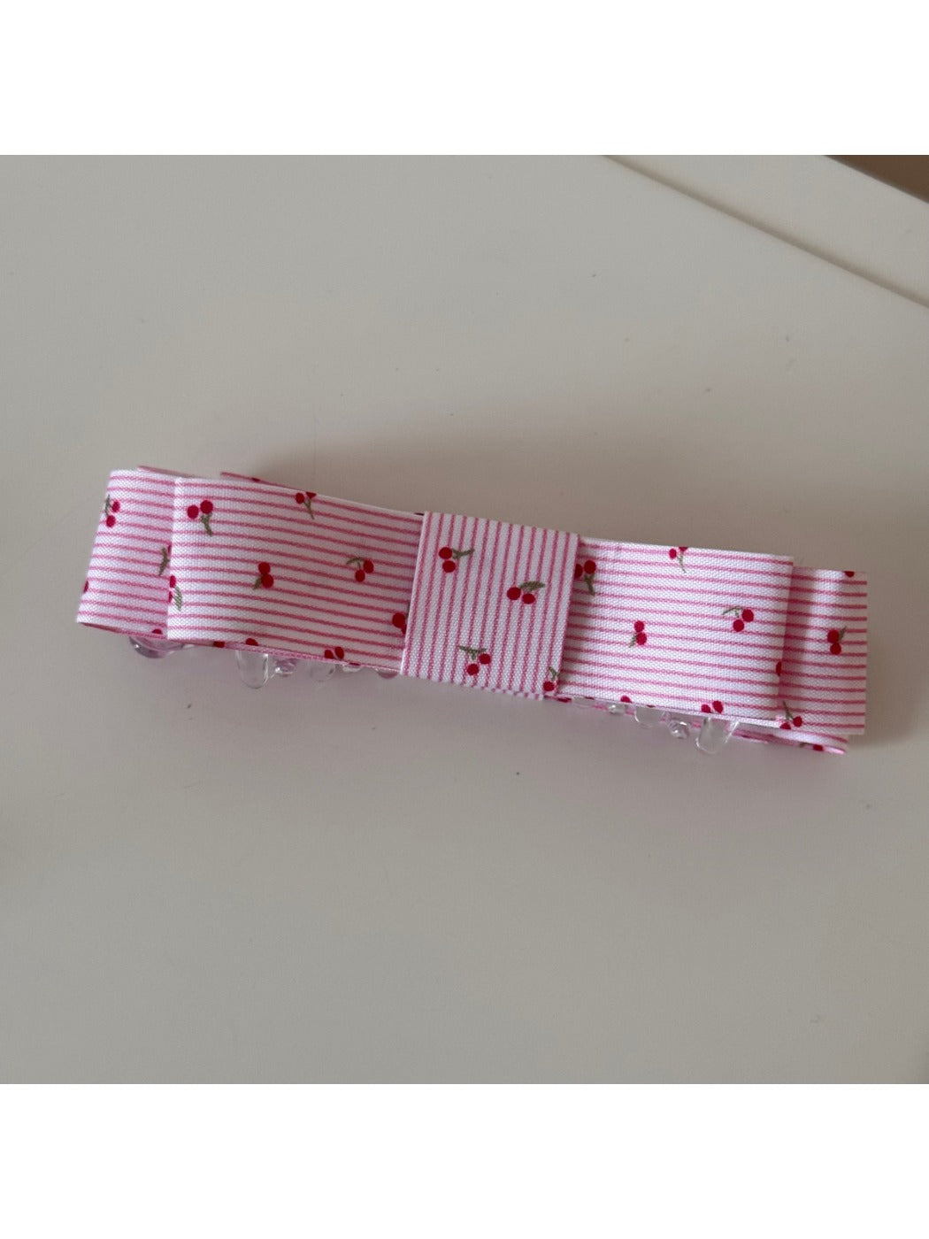 Top view of Beau pink floral pattern hair clip with metal clip visible