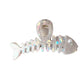 Beau hair clip placed on a wooden surface with natural lighting