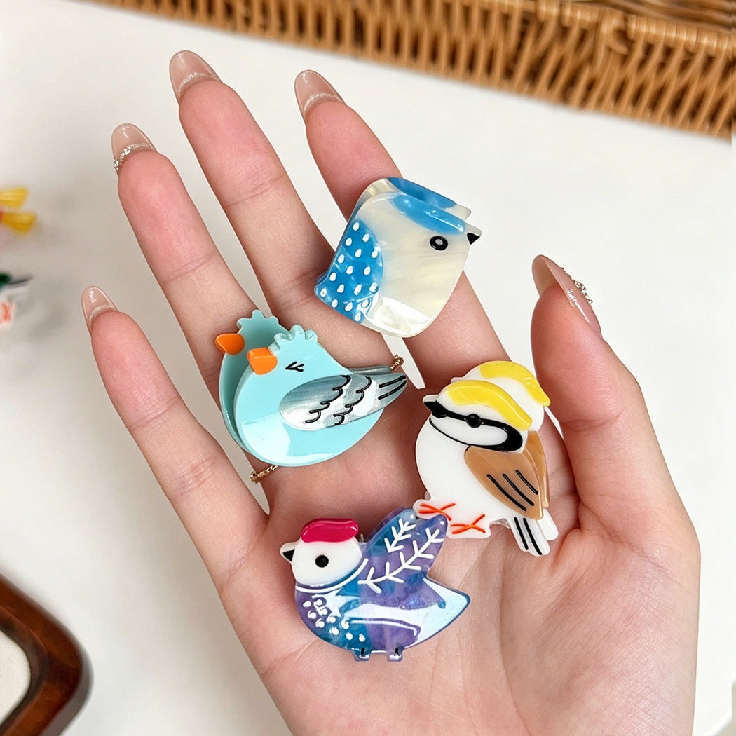 Mini bird character hair claw clips held in hand