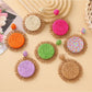 Close-up of Earedge raffia colorful round earrings on white background