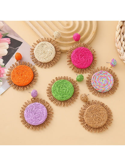 Close-up of Earedge raffia colorful round earrings on white background