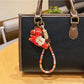 Keypus pony charm keychain attached to a set of keys on a wooden surface