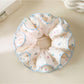 Close-up of pink scrunchie with colorful polka dots on fabric