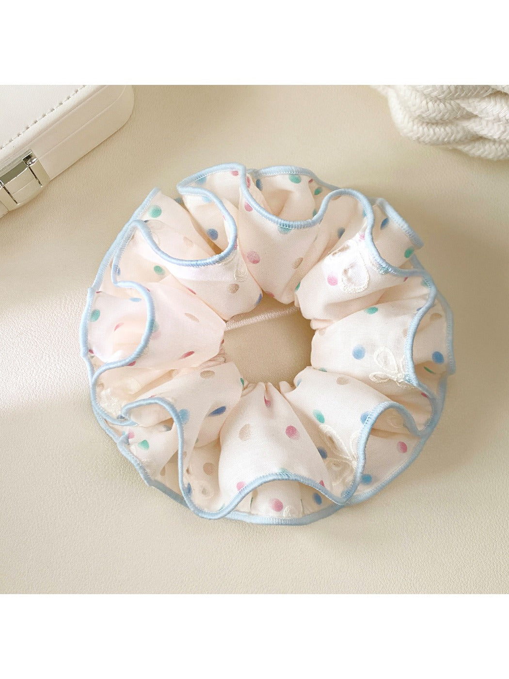 Close-up of pink scrunchie with colorful polka dots on fabric