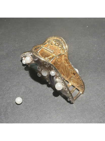 Beau hair clip displayed on a sandy beach setting with seashells