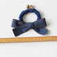 Vintage bow hair tie displayed flat on white background showing elastic band