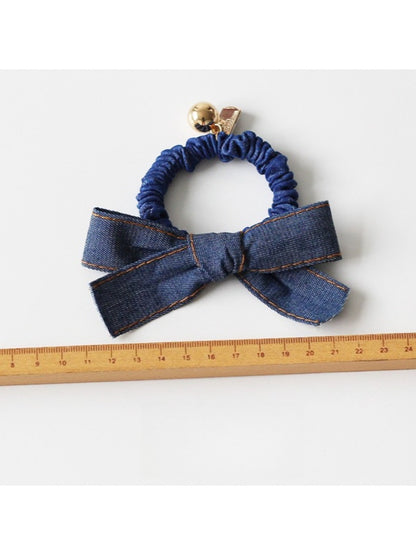 Vintage bow hair tie displayed flat on white background showing elastic band
