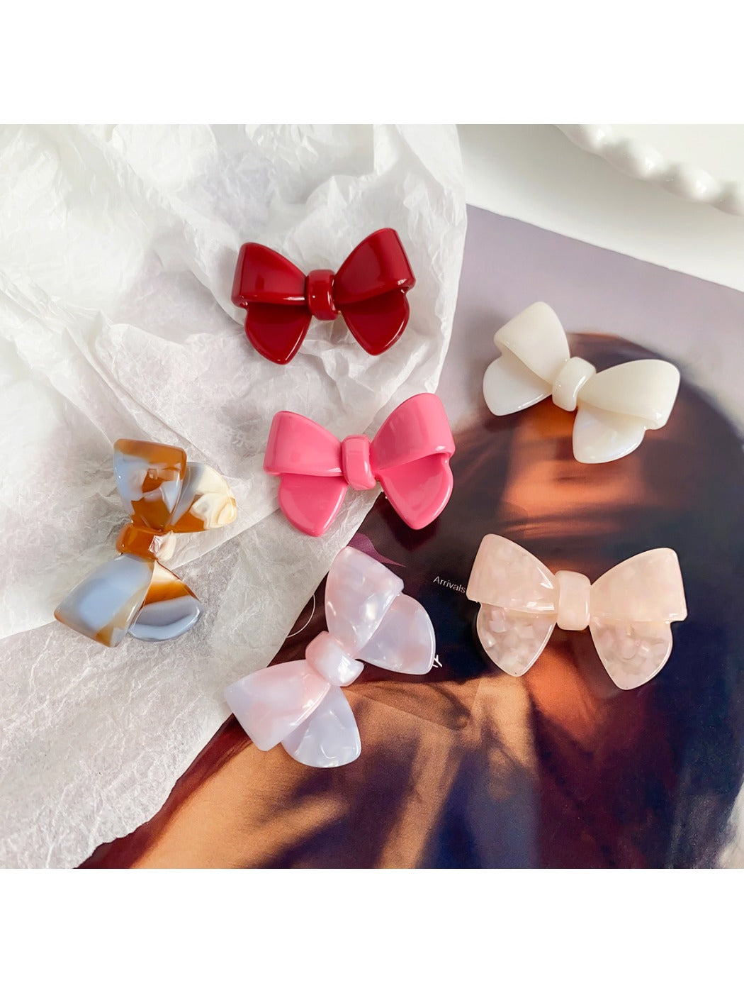 Beau delicate bow hair clip in soft pink fabric with gold accents on a white background