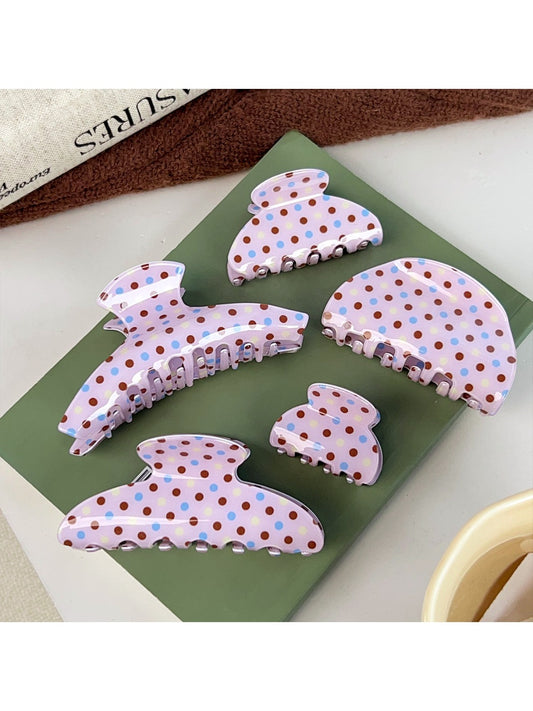 Beau crescent shaped pink claw clip with white polka dots on a white background