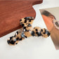 Beau elegant wavy hair claw clip next to matching hair accessories