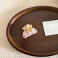 Beau floral pattern hair clip resting on a white surface with natural light