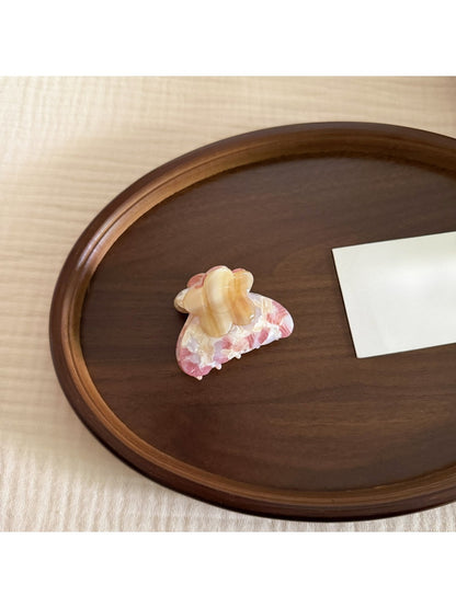Beau floral pattern hair clip resting on a white surface with natural light